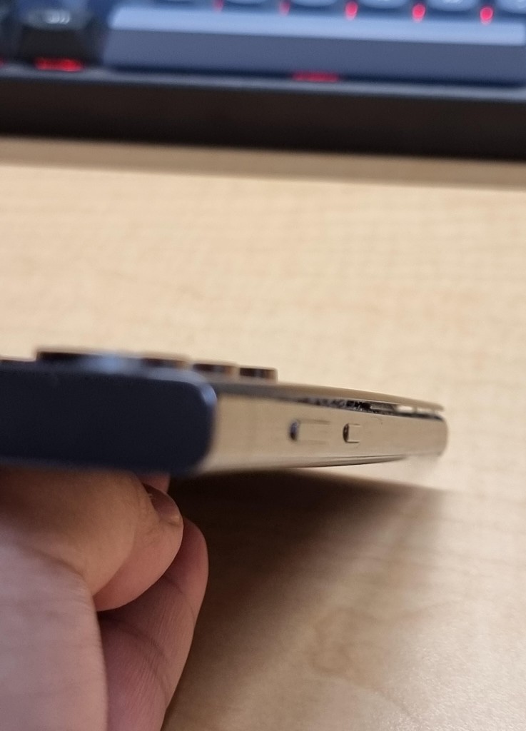 A phone with its back panel bulging out of the frame from a swollen battery
